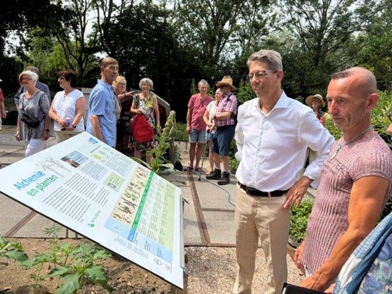 Wethouder Robert te Beest bewondert het informatiepaneel van het nieuwste tuindeel in de Hortus Alkmaar