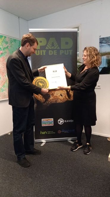 Karin Akkers van RAVON reikt de prijs uit aan wethouder Robert Barker van Den Haag op 10 december 2025