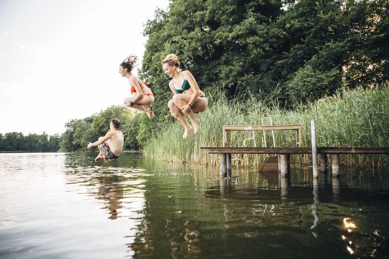 Zwemmers springen in het water
