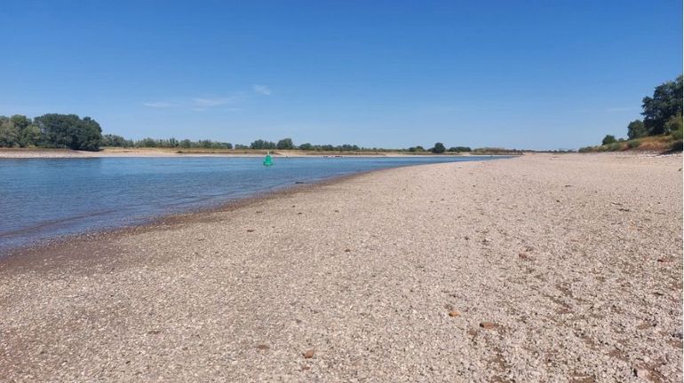 Drooggevallen grindbodem in de Waal bij de Millingerwaard. Op de achtergrond een groene boei waarachter de vaarweg ligt