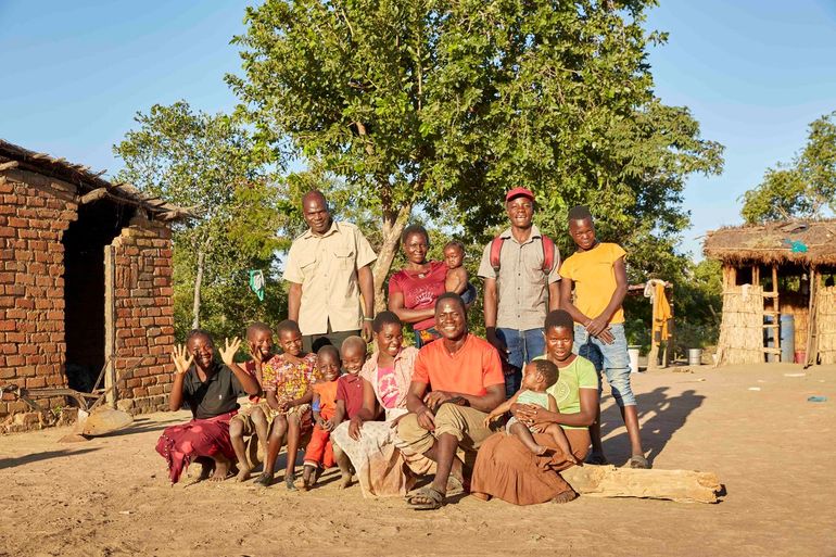 Smoke Phiri (achterste rij, helemaal links) poseert met zijn vrouw, hun kinderen en kleinkinderen op hun compound in Mwase Mphangwe, Zambia