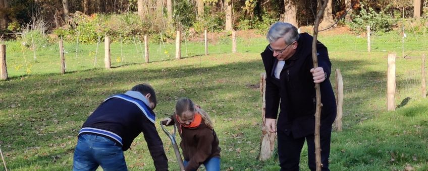 Gedeputeerde ten Bolscher plant met kinderen op landgoed Vilsteren de pronkboom, symbool voor de duizenden bomen die er bij komen.