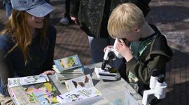 Jongen kijkt door microscoop tijdens Expeditie stadsnatuur