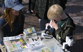 Jongen kijkt door microscoop tijdens Expeditie stadsnatuur