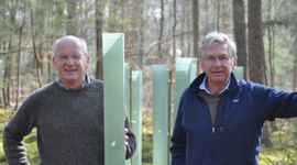 Anne van Leeuwen en Jaap Hülsmann, mede-eigenaren van het familielandgoed, bij recent aangeplante bomen. De kokers beschermen tegen wildvraat.