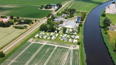 Op de voorgrond het voormalige landbouwperceel dat ingericht wordt met natuurzones