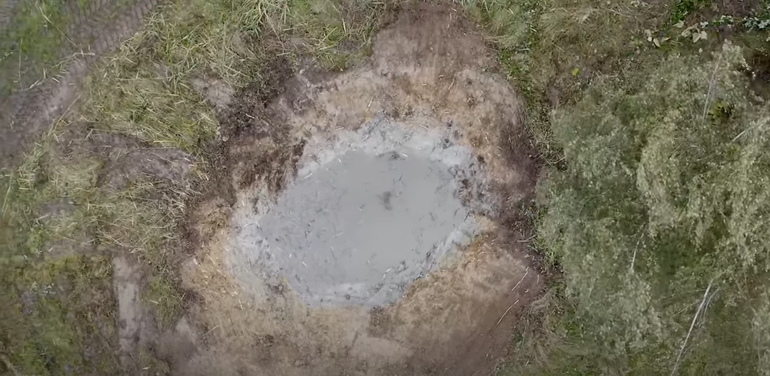 Still (drone) van een poel uit de video