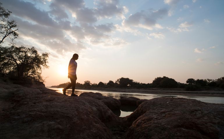 Agness walking next to the Luangwa river at sunset