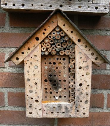 Goed werkend bijenhotel van hard hout en met verschillende typen gangen in hout en bamboe en een waterdicht afdakje