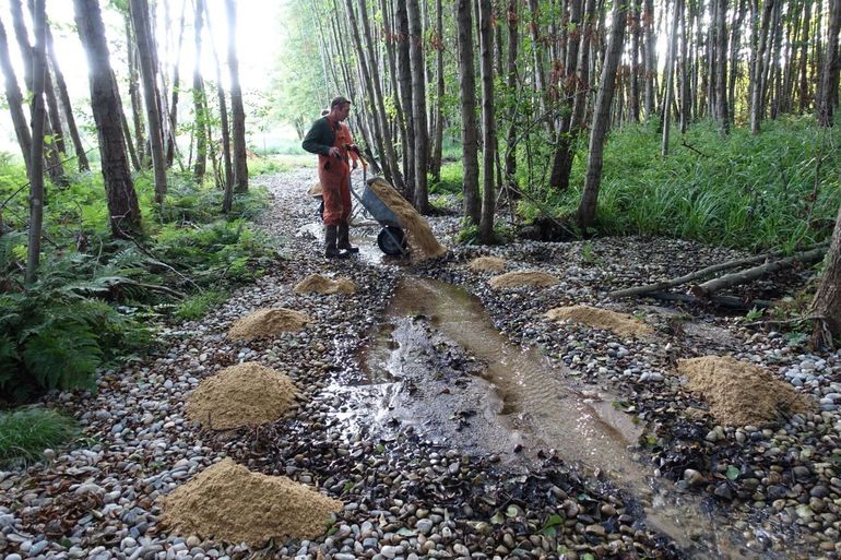 Een beek wordt opgevuld met grind en zand