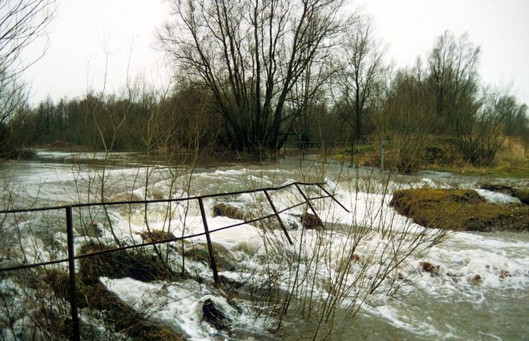 Instromend hoogwater bij de zandplas vernielt de ingang en het hek,1995