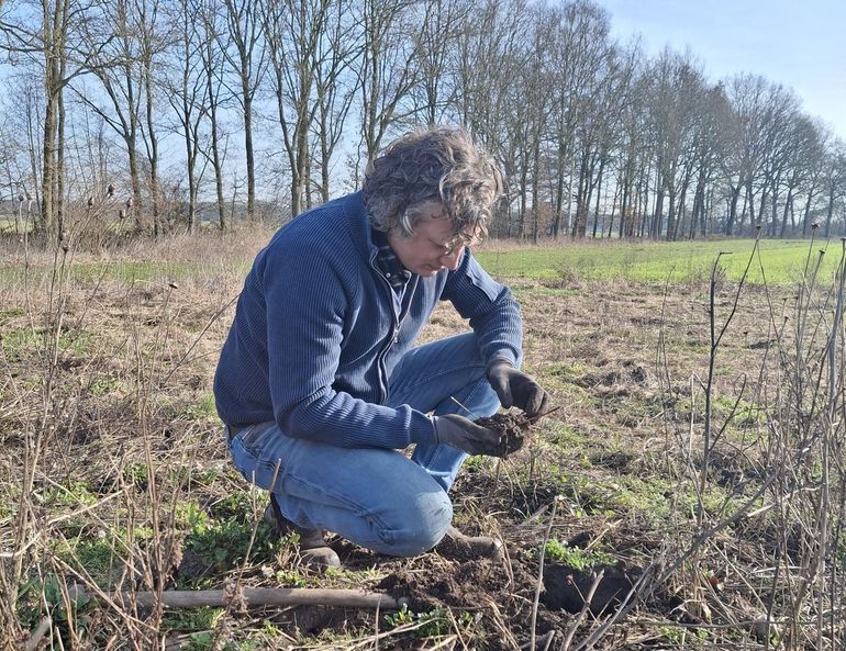 Chris Antuma onderzoekt de bodem in zijn kruidenrijke akkerrand