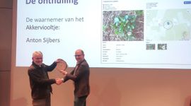 NDFF‑vertegenwoordiger Jan Willem van der Vegte overhandigt de erkenning van de 250 miljoenste waarneming in de NDFF aan Anton Sijbers uit Bakel, die de waarneming van het Akkerviooltje deed