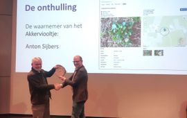 NDFF‑vertegenwoordiger Jan Willem van der Vegte overhandigt de erkenning van de 250 miljoenste waarneming in de NDFF aan Anton Sijbers uit Bakel, die de waarneming van het Akkerviooltje deed