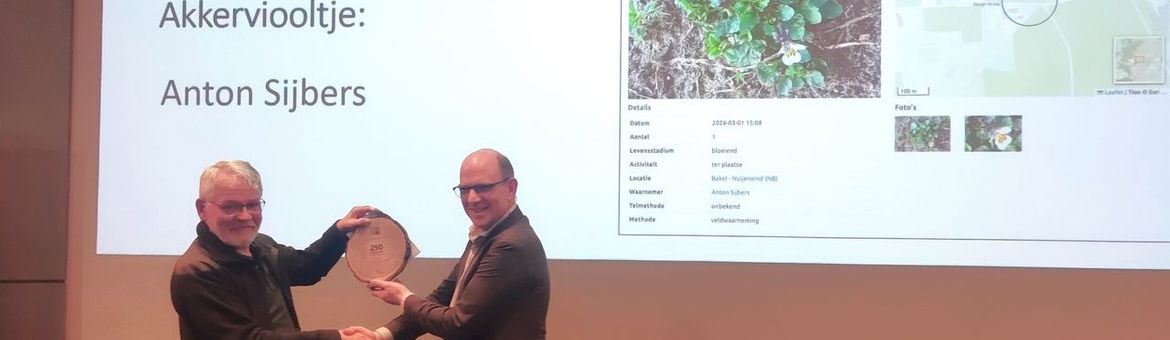 NDFF‑vertegenwoordiger Jan Willem van der Vegte overhandigt de erkenning van de 250 miljoenste waarneming in de NDFF aan Anton Sijbers uit Bakel, die de waarneming van het Akkerviooltje deed