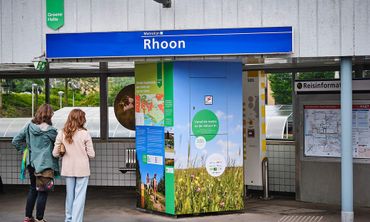 Het logo, een groen vaantje, links bovenin bij metrostation Rhoon