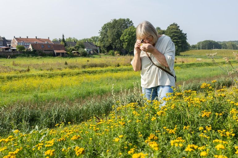 Emma gebruikt een loep om planten goed te kunnen bekijken