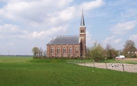 Kerk te Warstiens, Friesland. Op de achtergrond is de oprukkende stad Leeuwarden te zien