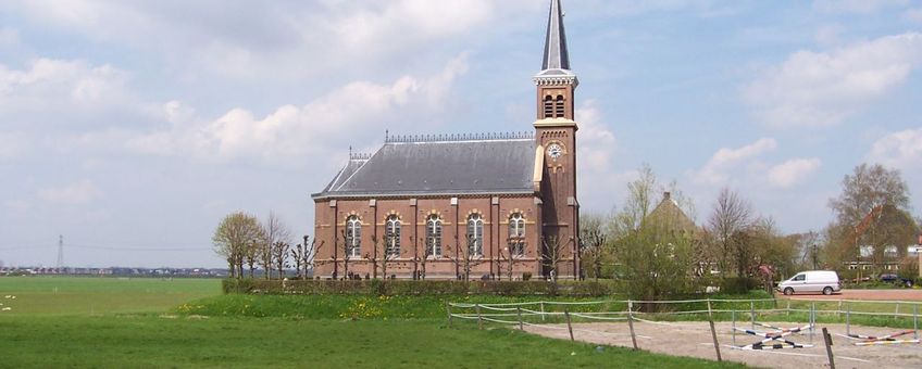 Kerk te Warstiens, Friesland. Op de achtergrond is de oprukkende stad Leeuwarden te zien