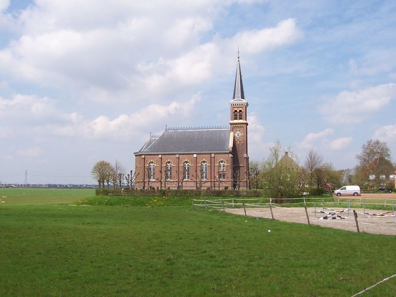 Kerk te Warstiens, Friesland. Op de achtergrond is de oprukkende stad Leeuwarden te zien