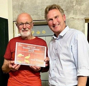 Winnaar Henk Klaassen (links) ontvangt de Gouden Lepelaar en oorkonde van Floris van Kuijk van Vogelbescherming