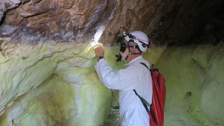 De Roemeense speleoloog Serban Sarbu verzamelt monsters in de grot. Het heet hier Puturosu Mountain: de Stinkende berg. De onderste helft van de wand ziet gifgeel van de zwavel. Net daarboven leeft een laag bijzondere micro-organismen