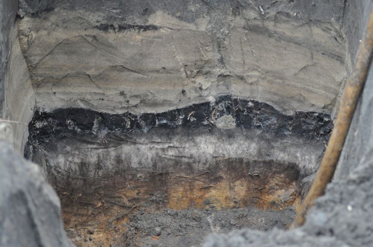 Bodemonderzoek geeft inzicht in de landschapsdynamiek door de tijd. Onderin een moerpodzolgrond, ontstaan door een vernattend landschap. Het gele gelaagde pakket bevat stuifzand en is rond 1600 AD afgezet. Vanaf 1700 AD is dit stuifzand met plaggen overdekt en is men het gebied gaan cultiveren. Uit de combinatie van bodemkundig onderzoek, dateringsonderzoek, pollenonderzoek en historisch onderzoek blijkt dat hier in Noordoost-Twente in de afgelopen vierhonderd jaar drie totaal verschillende landschappen aanwezig waren