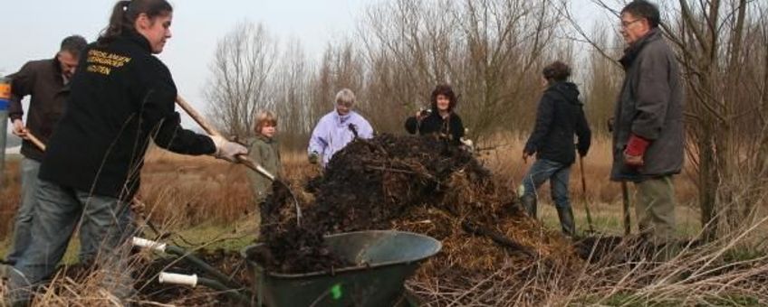 Vrijwilligers leggen een nieuwe broeihoop aan