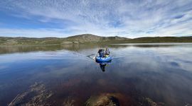 Researchers in a boat sample a lake near Kangerlussuaq, Greenland, that browned after the extreme events.