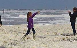 Plezier met schuim op het strand