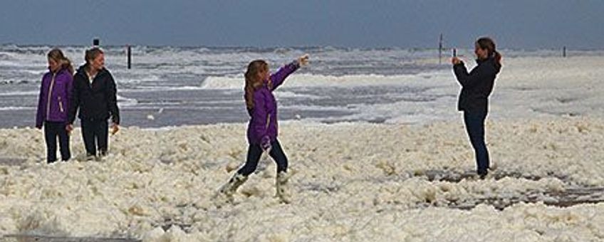 Plezier met schuim op het strand