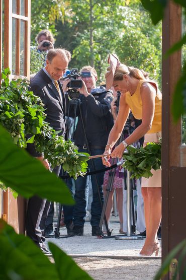 Koningin Máxima naast de teakhouten kasdeuren