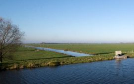 Akker met slootjes en watergemaal