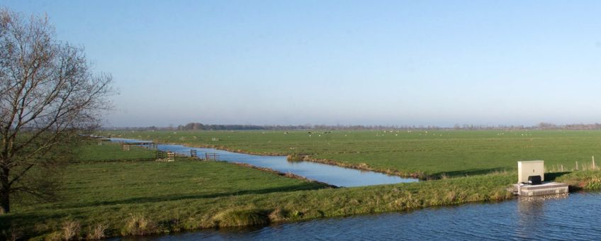 Akker met slootjes en watergemaal